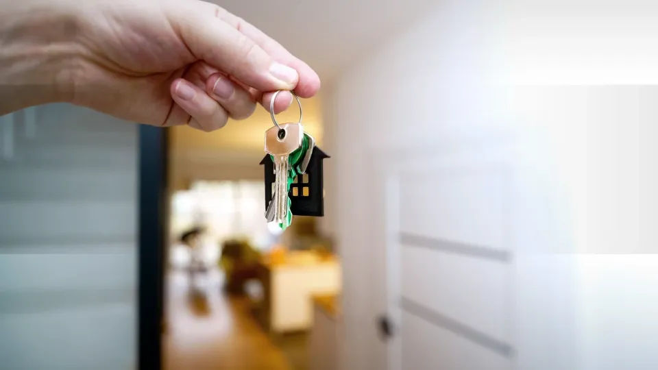 Hand hält Wohnungsschlüssel als Symbol für Neuvermietung durch die Hausverwaltung