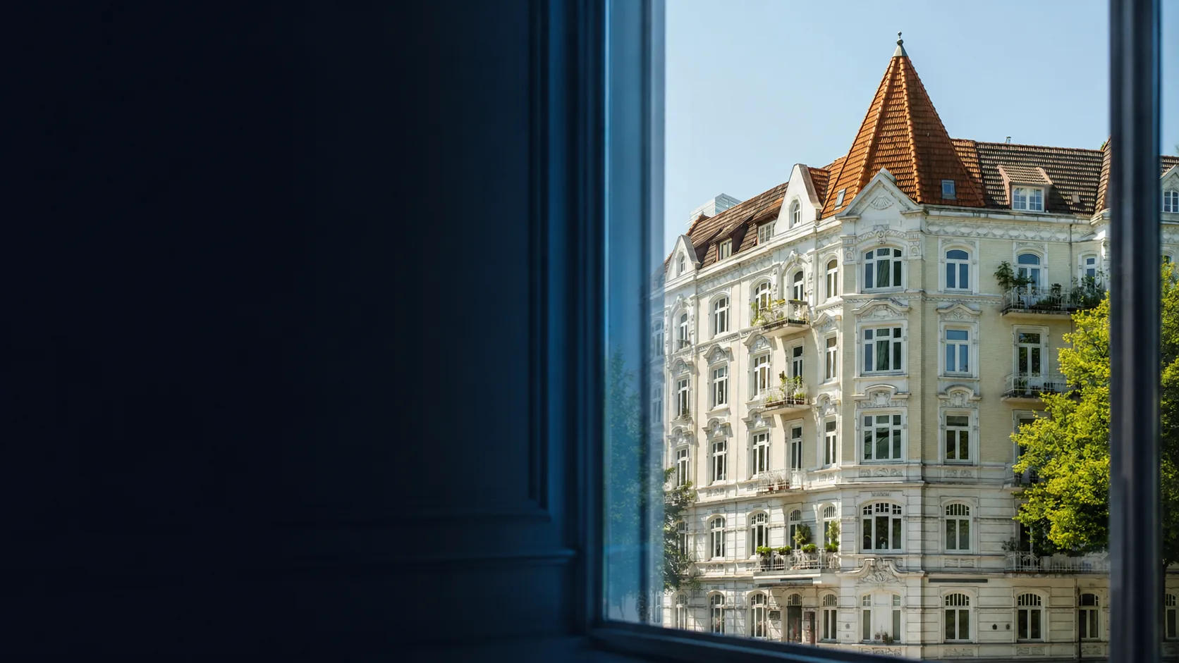 Historisches Wohngebäude durch ein Fenster als Hero-Bild für WEG-Verwaltung